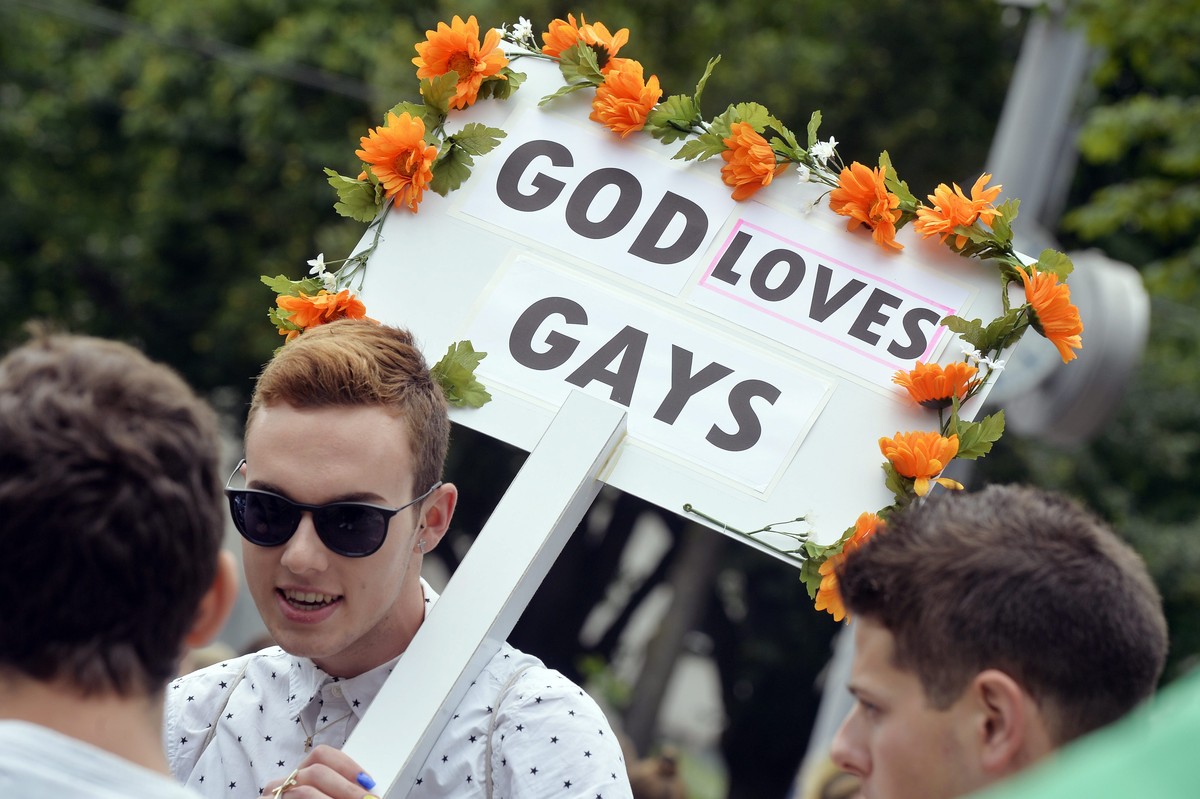 epa04810767 A participant carries a sign reading 'God loves gays' during the Zurich Pride Parade, in Zurich, Switzerland, 20 June 2015. The slogan of the 2015 edition of the Pride parade, a  ...