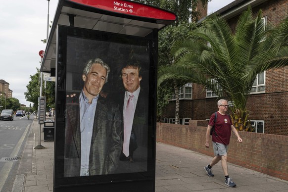 Commuters walk past a bus stop near Nine Elms Station as activists put up a poster showing President Donald Trump and Jeffrey Epstein near the US Embassy in London, Thursday, July 17, 2025.(AP Photo/T ...