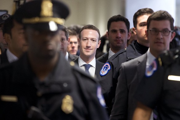 epaselect epa06657822 CEO of Facebook Mark Zuckerberg (C) is surrounded by Capitol Police officers as he walks down a hallway to the office of Democratic Senator from California Dianne Feinstein, on C ...