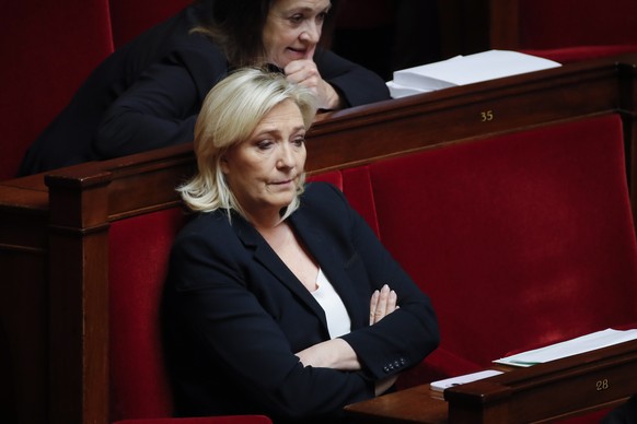 epa10533822 French member of Parliament and leader of the far-right party Rassemblement National (RN) Marine Le Pen (C) listens to speeches during the examination of two motions of no-confidence again ...