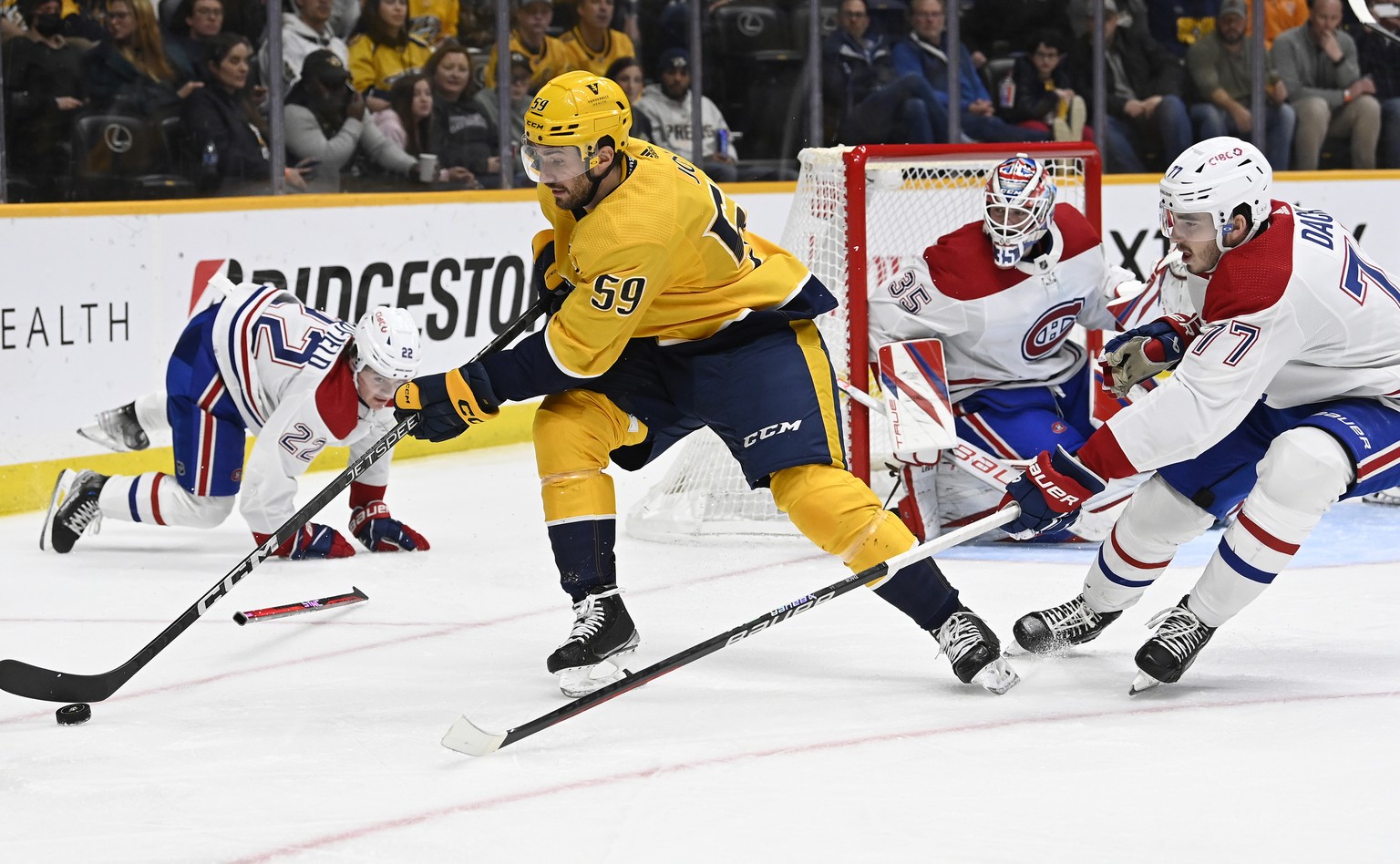 Nashville Predators defenseman Roman Josi (59) gets control of the puck as Montreal Canadiens center Kirby Dach (77) reaches in during the second period of an NHL hockey game Tuesday, Jan. 3, 2023, in ...