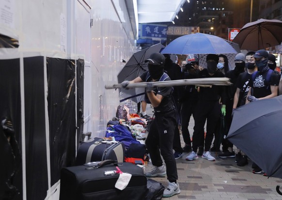 Protestors damage a wall of Bank of China in Hong Kong, Sunday, Oct.13, 2019. Protesters changed tactics and popped up in small groups in multiple locations across the city Sunday rather than gather i ...