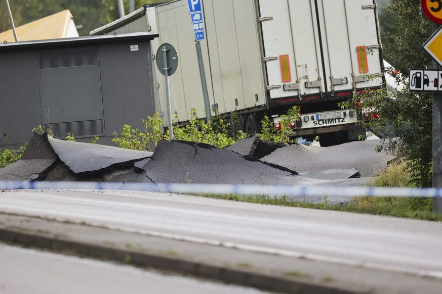 epa10878134 A view of the damage at the E6 near Stenungsund, Sweden, 23 September 2023, after persistent rain caused a large sinkhole in which several cars and a bus went down. According to the police ...