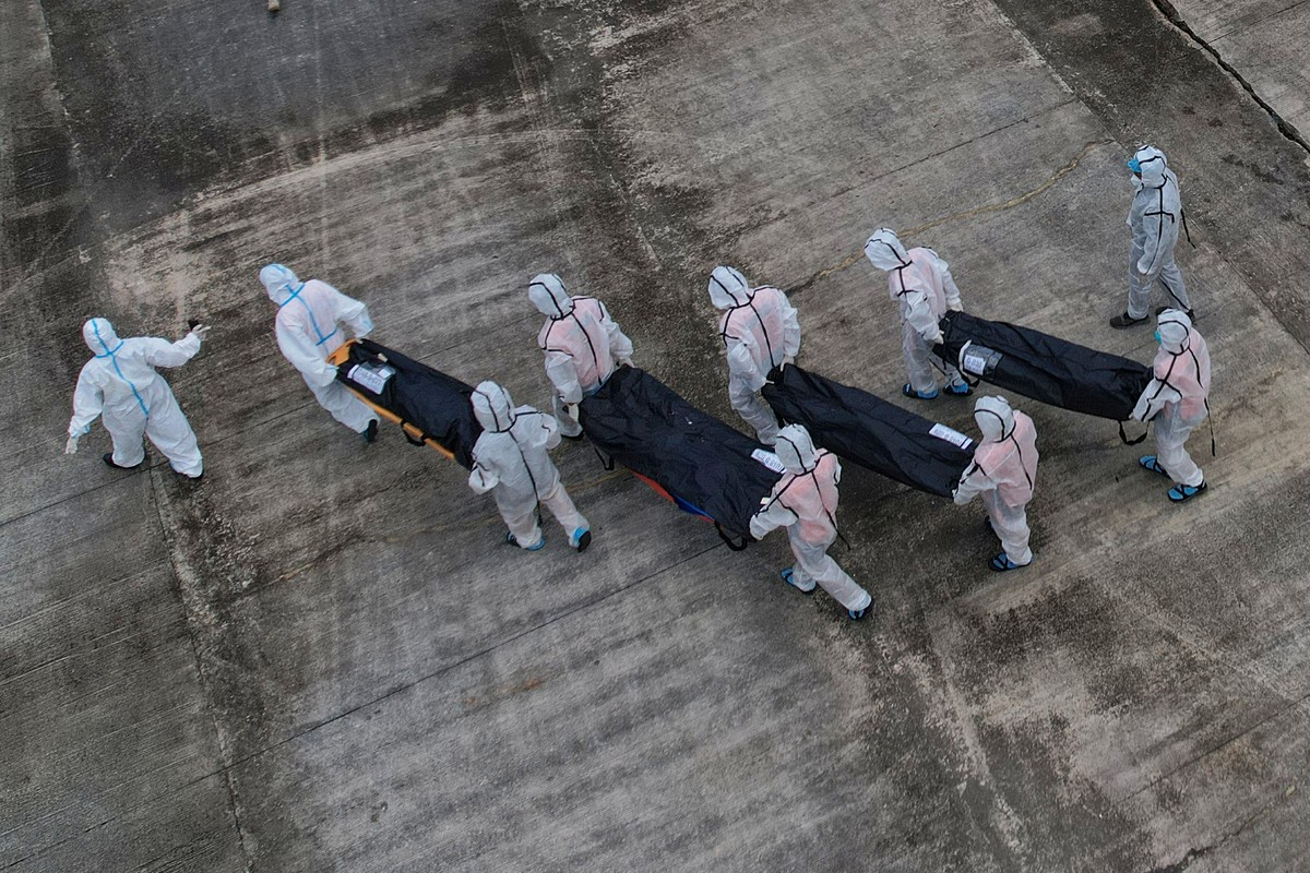 Rescuers carry the remains of victims of the recent fire on the MV June Aster ferry as they arrive on board a Philippine Coast Guard vessel at the Borac port in Coron, Palawan province, western Philip ...