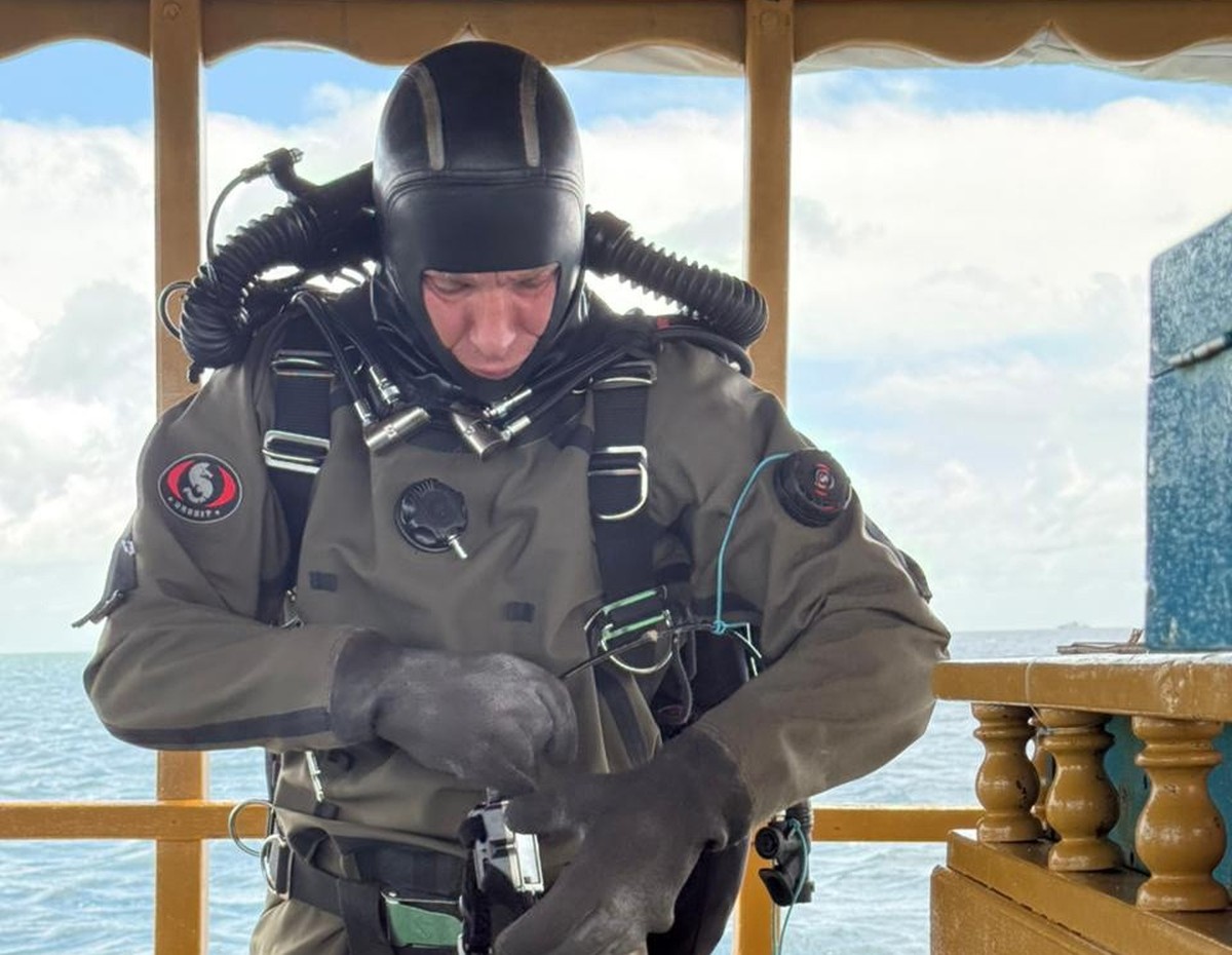 epa12972836 A handout photo made available by the Maldives President's Media Division shows Finnish diver Patrik Gronqvist preparing to conduct search and recovery operations for the bodies of fo ...