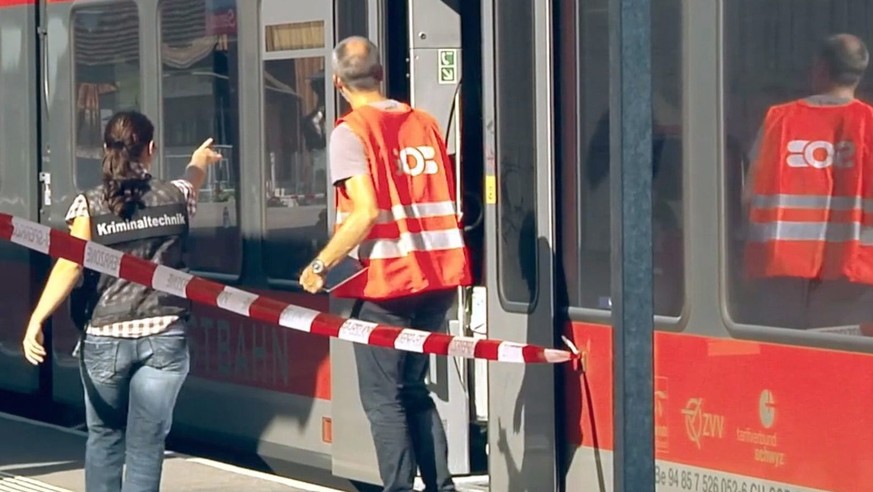 epa05483433 A still image from a video taken 13 August 2016 shows a train standing at the trainstation Salez - Sennwald where it is inspected by forensic experts following an attack onboard a train, i ...