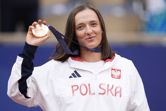 FILE - Poland&#039;s Iga Swiatek shows her bronze medal after the Women&#039;s Singles tennis final at the Roland Garros stadium at the 2024 Summer Olympics, Saturday, Aug. 3, 2024, in Paris, France.  ...