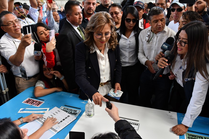 epa10810464 The former first lady and candidate for the Presidency of Guatemala Sandra Torres (C), of the National Unity of Hope (UNE), votes during the second round of the presidential elections, in  ...