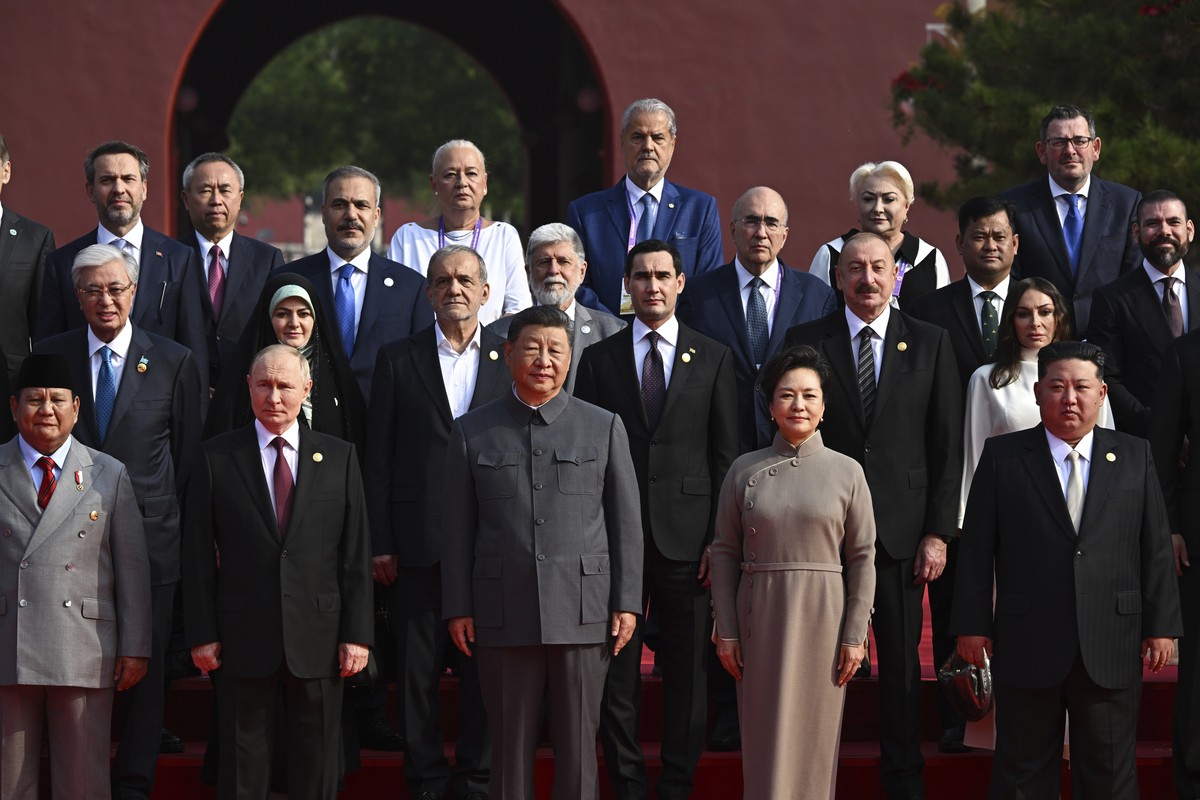Chinese President Xi Jinping, center, with his wife Peng Liyuan, front second right, and other leaders pose for a group photo ahead of a military parade to commemorate the 80th anniversary of Japan  ...