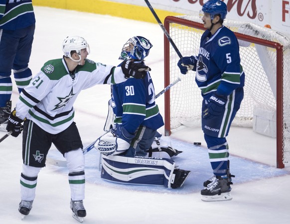 Dallas Stars left wing Antoine Roussel (21) celebrates his goal past Vancouver Canucks goalie Ryan Miller (30) as defenseman Luca Sbisa (5) looks on during the third period of an NHL hockey game in Va ...