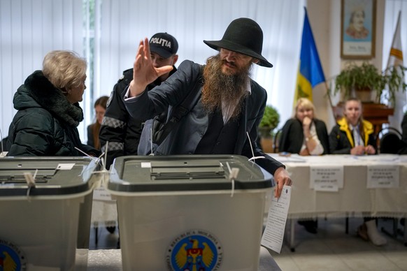 A man gestures after casting his vote in Chisinau, Moldova, Sunday, Oct. 20, 2024, during a presidential election and a referendum on whether to enshrine in the Constitution the country&#039;s path to ...