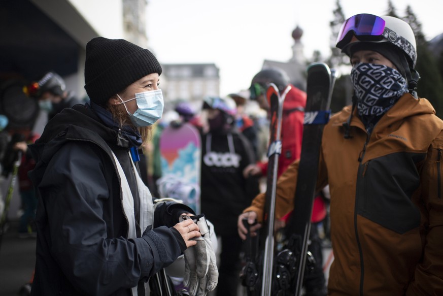 Menschen mit Schutzmasken warten auf die Parsenn-Bahn, aufgenommen zum Start der Skisaison, am Sonntag, 25. Oktober 2020, in Davos. Das Skigebiet Davos Klosters startet den Wochenendbetrieb. (KEYSTONE ...