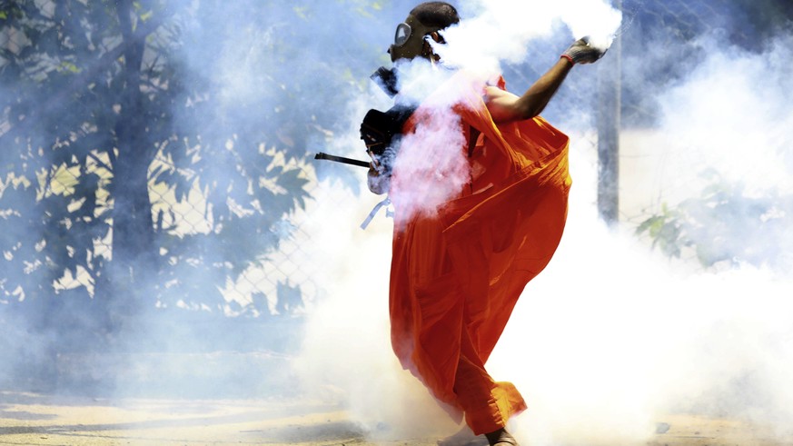 A man throws back a tear gas canister after it was fired by police to disperse protesters in Colombo, Sri Lanka, Saturday, July 9, 2022. Sri Lankan protesters demanding that President Gotabaya Rajapak ...
