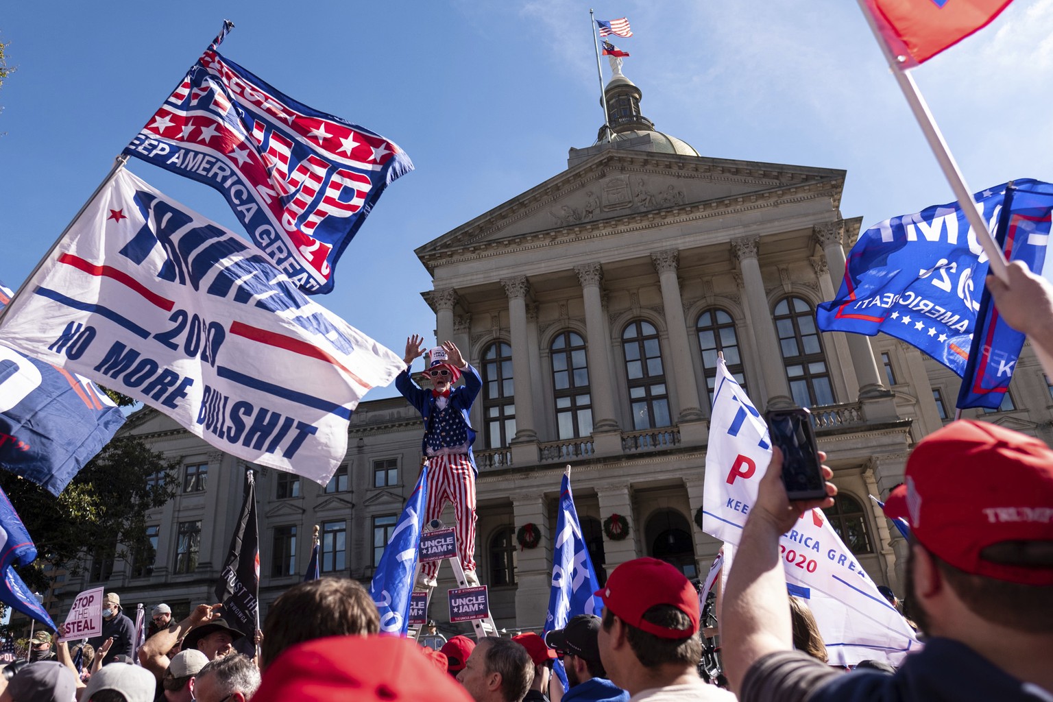 Supporters of President Donald Trump rally outside of the Georgia State Capitol in Atlanta on Saturday, Nov. 21, 2020. (AP Photo/Ben Gray)