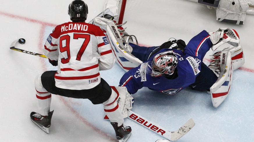 Canadas Connor McDavid, left, attacks the net of Frances goalkeeper Ronan Quemener during the Hockey World Championships Group B match in St.Petersburg, Russia, Monday, May 16, 2016. (AP Photo/Dmitr ...