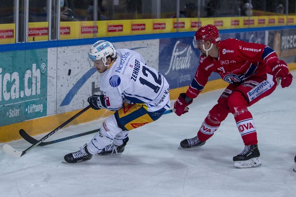 EV Zug Stuermer Yannick Zehnder, links, gegen SC Rapperswil-Jona Lakers Verteidiger Igor Jelovac waehrend dem Eishockey-Meisterschaftsspiel der National League zwischen den SC Rapperswil-Jona Lakers u ...