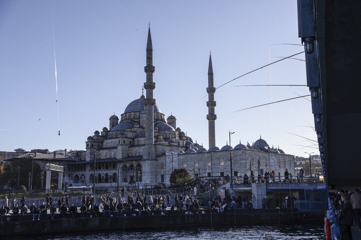 epa12547574 People walk in front of the Eminonu New Mosque in Istanbul, Turkey, 25 November 2025. Pope Leo XIV is scheduled to meet Ecumenical Patriarch Bartholomew I, spiritual leader of the Greek Or ...