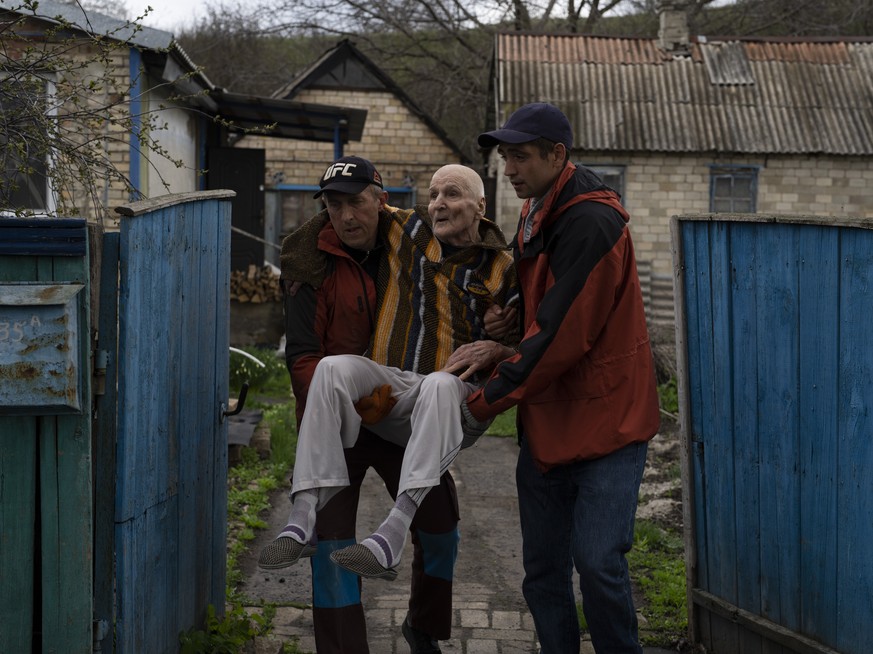 Elderly people are evacuated from a hospice in Chasiv Yar city, Donetsk district, Ukraine, Monday, April 18, 2022. At least 35 men and women, some in wheelchairs and most of them with mobility issues, ...