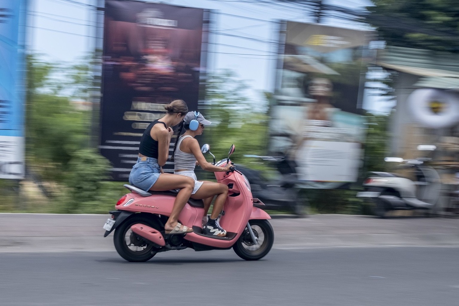 epa10521863 Foreign tourists ride a scooter at a main road in Canggu, Bali, Indonesia, 14 March 2023. The Bali provincial government on 13 March announced a plan to ban for foreign tourists from opera ...