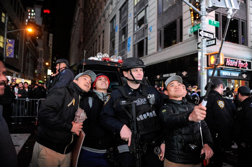 People take a selfie with a member of the counter terrorism task force in Times Square in New York, U.S. January 1, 2017. REUTERS/Stephanie Keith