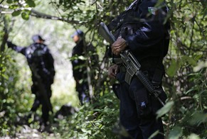 Polizisten sichern den Ort, an dem ein neues Grab entdeckt wurde.