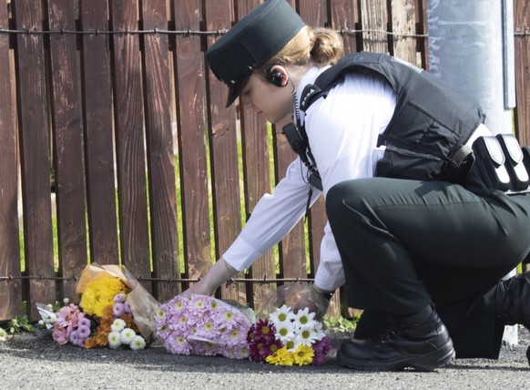 Eine Polizistin legt Blumen nieder, wo die Journalistin Lyra McKee von einer Kugel getroffen wurde und starb. Die Ordnungshüter vermuten, dass katholische Extremisten hinter der Tat stehen.