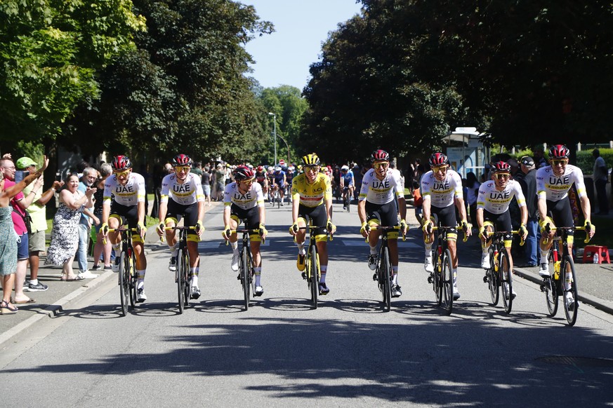 epa09352041 Slovenian rider Tadej Pogacar (C) of the UAE-Team Emirates wearing the overall leader&#039;s yellow jersey is flanked by teammates during the 21st stage of the Tour de France 2021 over 108 ...