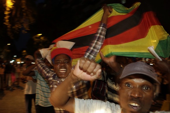 Zimbabweans celebrate in neighbouring Hillbrow, Johannesburg, South Africa, Tuesday, Nov. 21, 2017. Mugabe resigned as president with immediate effect Tuesday after 37 years in power, shortly after pa ...