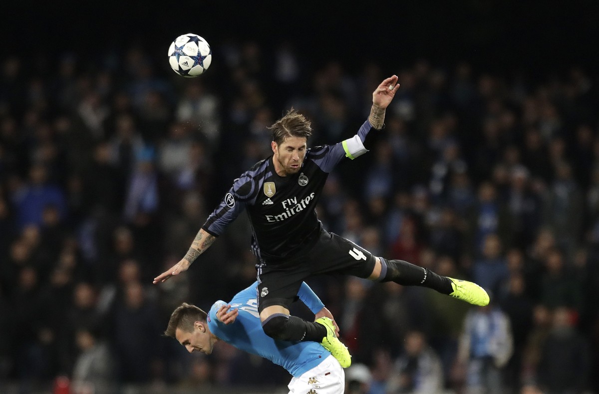 Real Madrid's Sergio Ramos falls on Napoli's Nikola Maksimovic during the Champions League round of 16, second leg, soccer match between Napoli and Real Madrid at the San Paolo stadium in Na ...