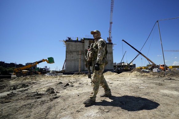 A Russian soldier guards the site of a new apartment block that is being built with support of Russia Defense Ministry in Mariupol, on the territory which is under the Government of the Donetsk People ...