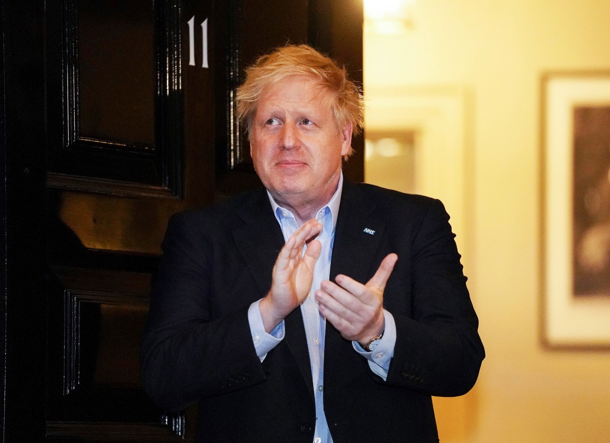 epa08339744 A handout photo made available by No. 10 Downing Street of Britain's Prime Minister Boris Johnson applauding during a 'Claps for our Carers' outside 11 Downing Street in Lon ...