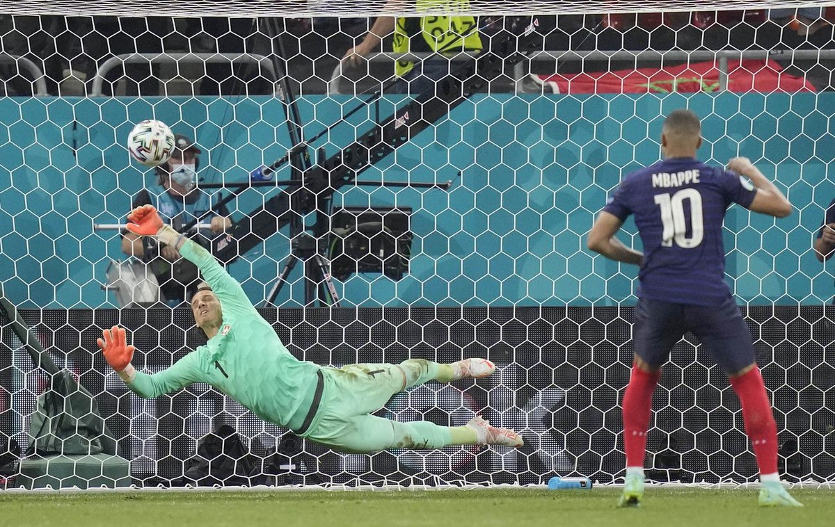 Switzerland's goalkeeper Yann Sommer saves the penalty shot by France's Kylian Mbappe during the Euro 2020 soccer championship round of 16 match between France and Switzerland at the Nationa ...