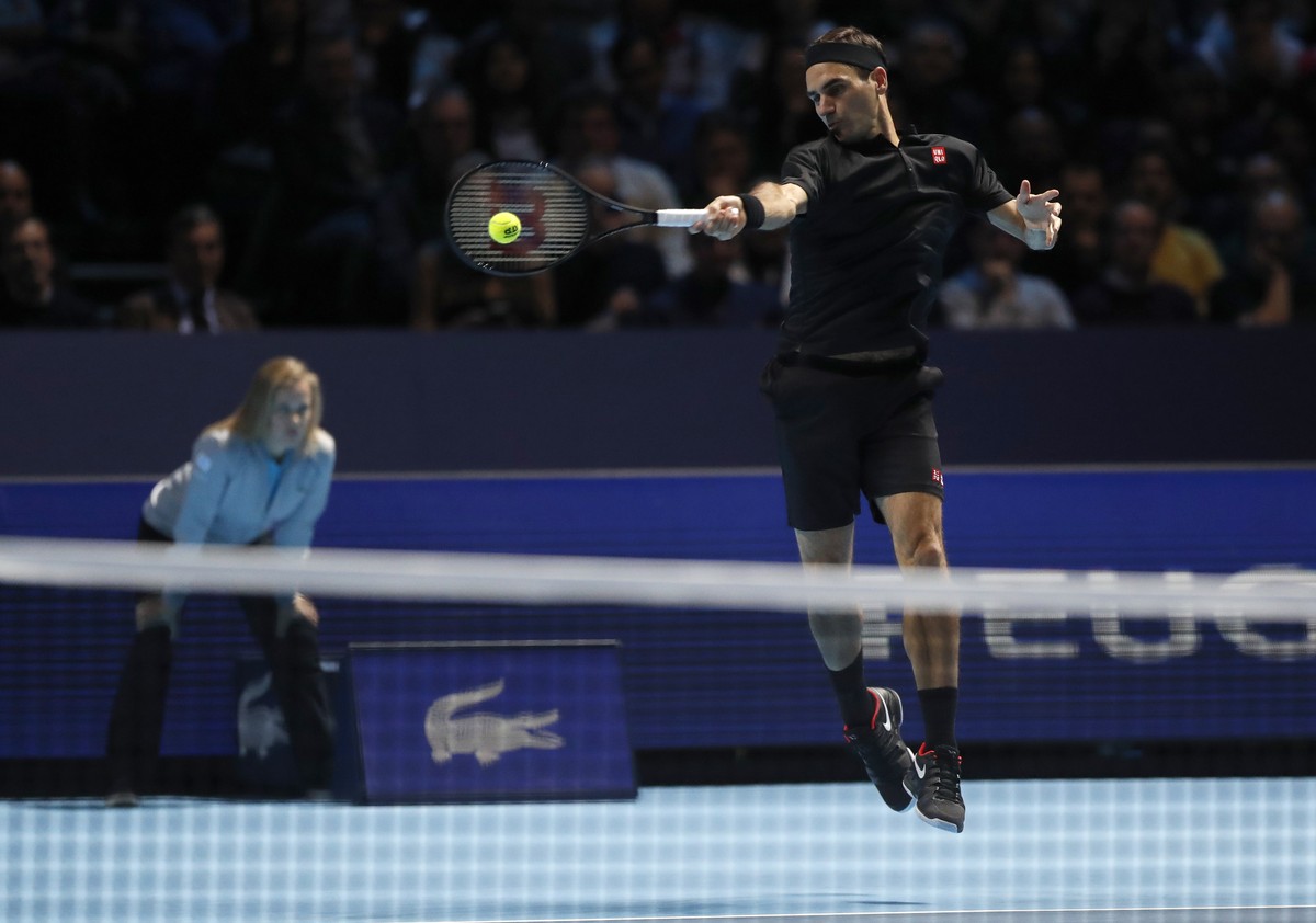 Switzerland's Roger Federer plays a return to Italy's Matteo Berrettini during their ATP World Tour Finals singles tennis match at the O2 Arena in London, Tuesday, Nov. 12, 2019. (AP Photo/A ...