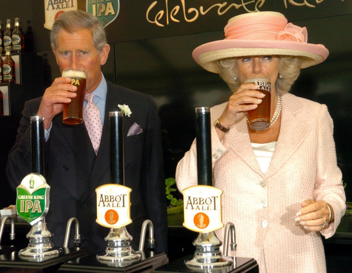 Britain's Prince Charles and the Duchess of Cornwall sample pints of beer, during a visit to Bury St Edmunds, England, Friday July 22, 2005, where they tried their hand at pulling pints at a beer ...