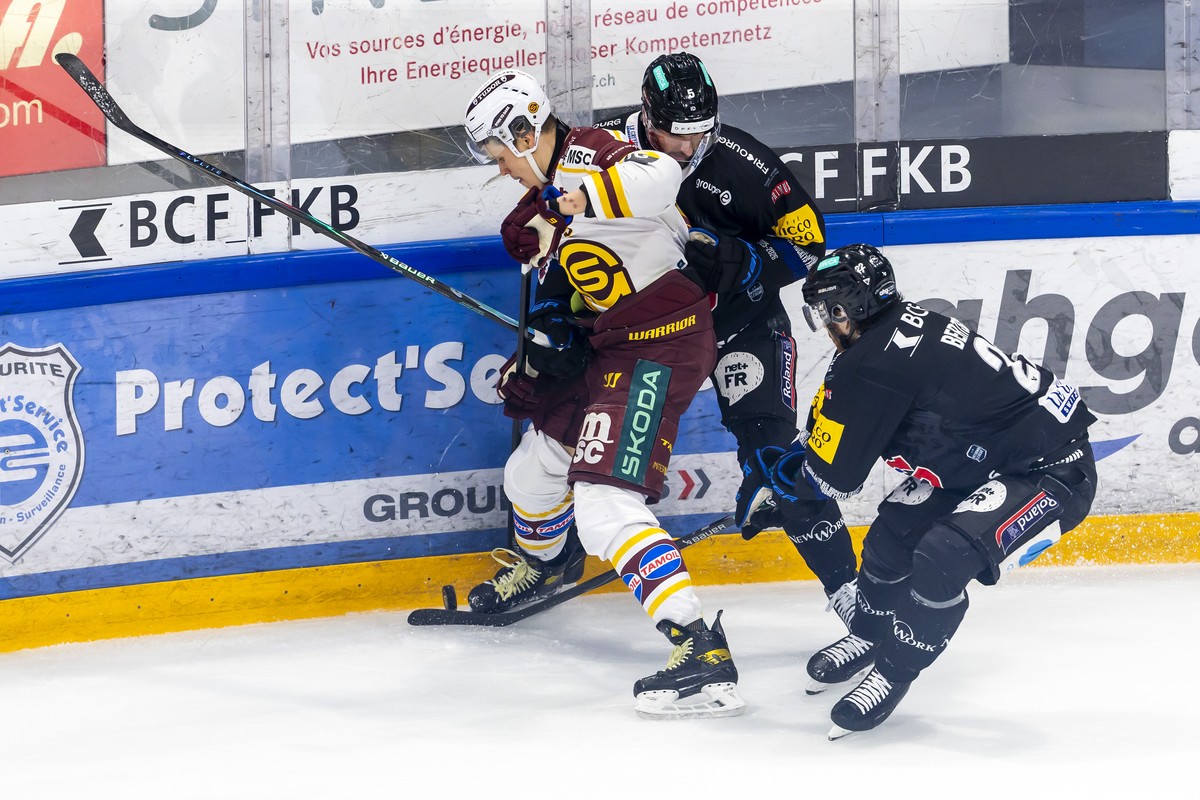 Jesse Puljujaervi (GSHC), left, vies for the puck with Simon Seiler (HCFG) #5 and Christoph Bertschy (HCFG), right, during the fifth leg of the National League semifinal playoff game of the Swiss Cham ...