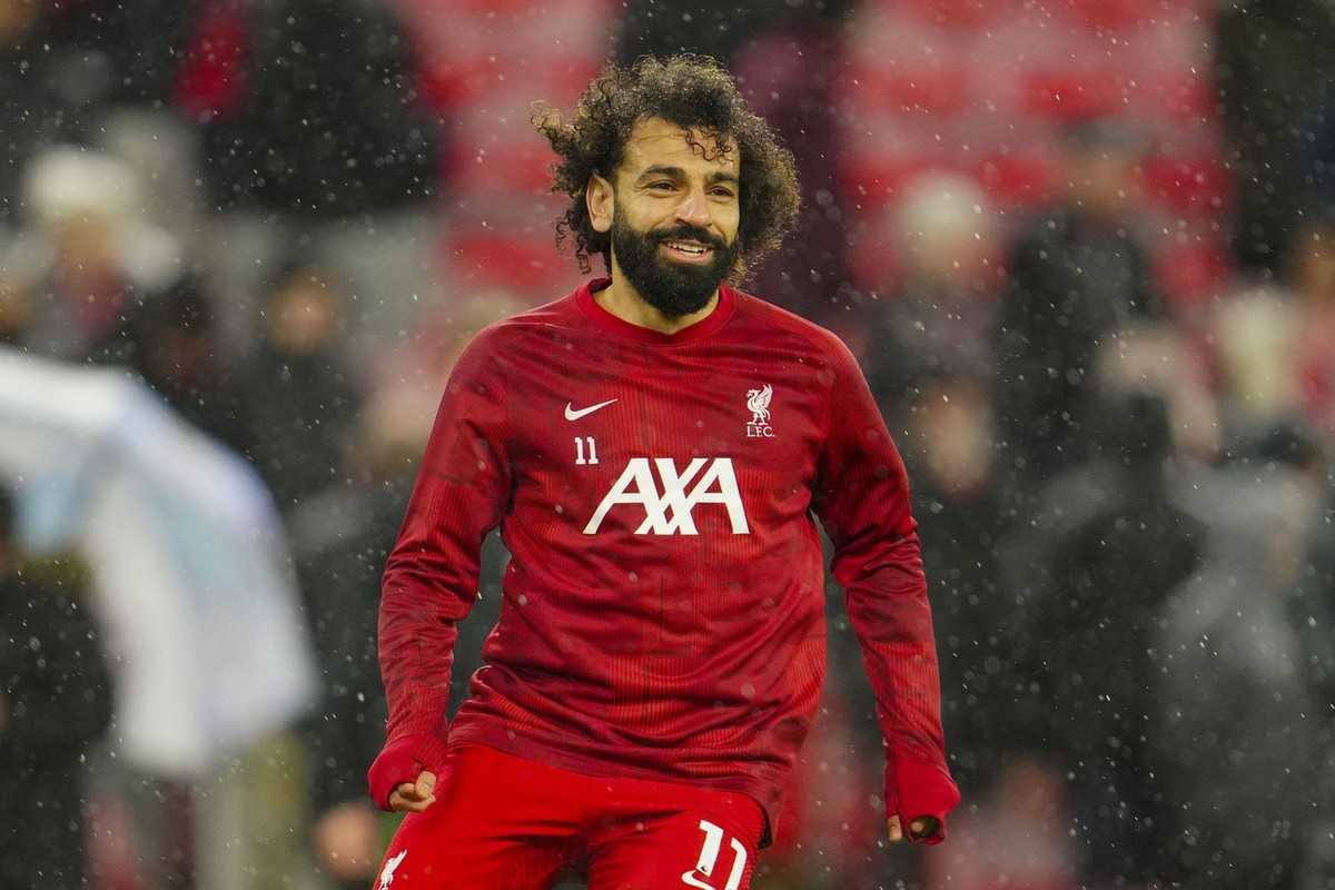 Liverpool's Mohamed Salah runs during warm up before the English Premier League soccer match between Liverpool and Newcastle, at Anfield stadium in Liverpool, England, Monday, Jan. 1, 2024. (AP P ...