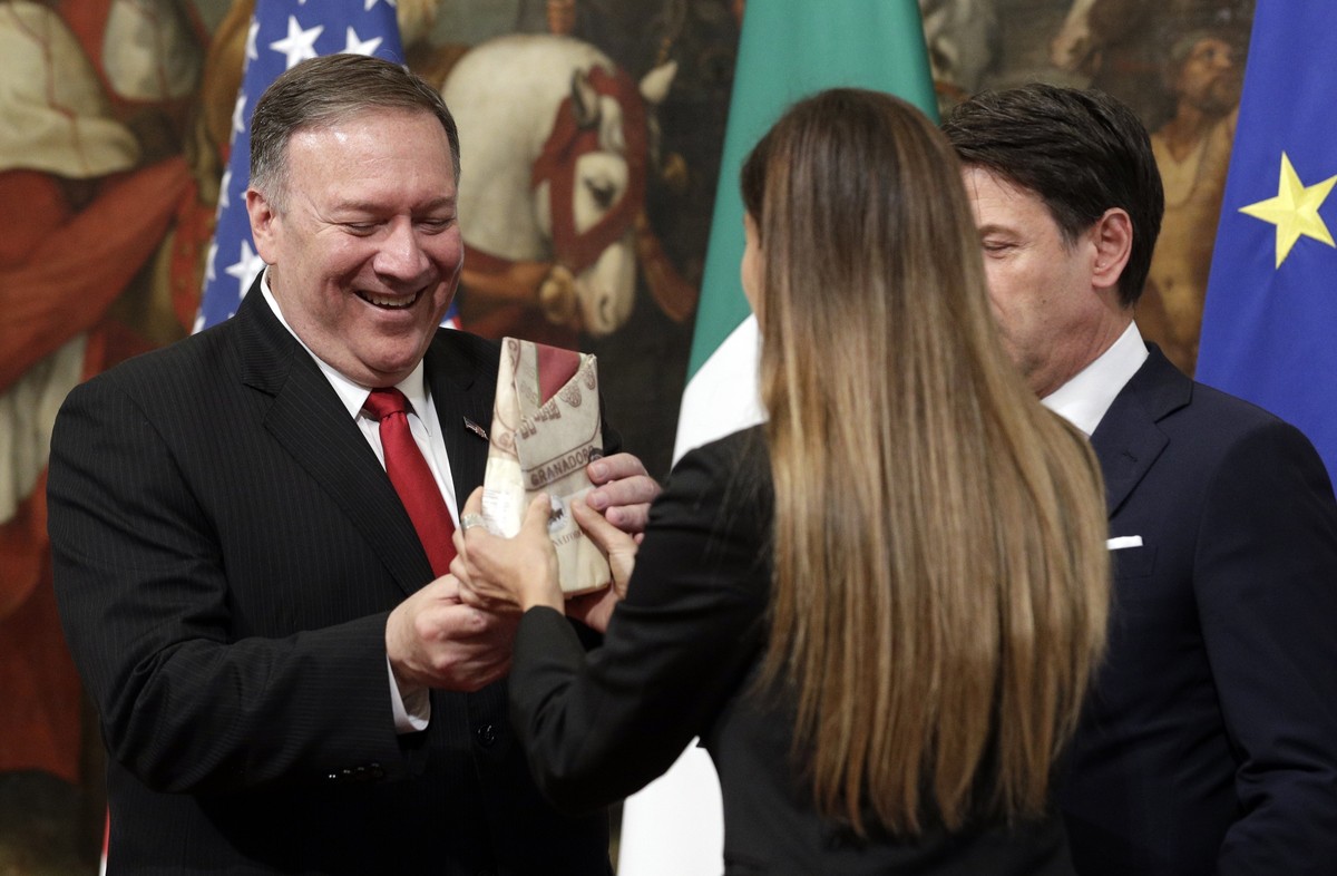 U.S. Secretary of State Mike Pompeo is given a package of Parmesan cheese as Italian Premier Giuseppe Conte, right, looks on, following their meeting at Chigi Palace premier's office in Rome, Tue ...