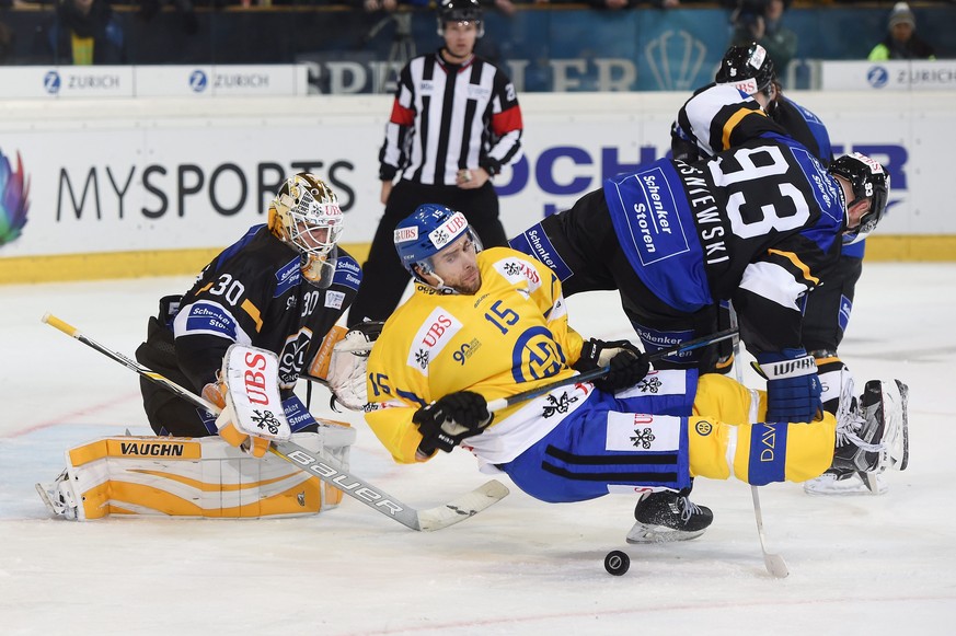 epa05692238 Davos Tuomo Ruutu, fights for the puck against Luganos goalkeeper Elvis Merzlikins and James Wisniewski during the game between Switzerlands HC Lugano and Switzerlands HC Davos at the 90th ...