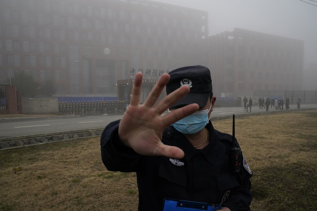 FILE - A security person moves journalists away from the Wuhan Institute of Virology after a World Health Organization team arrived for a field visit in Wuhan in China's Hubei province on Feb. 3, ...