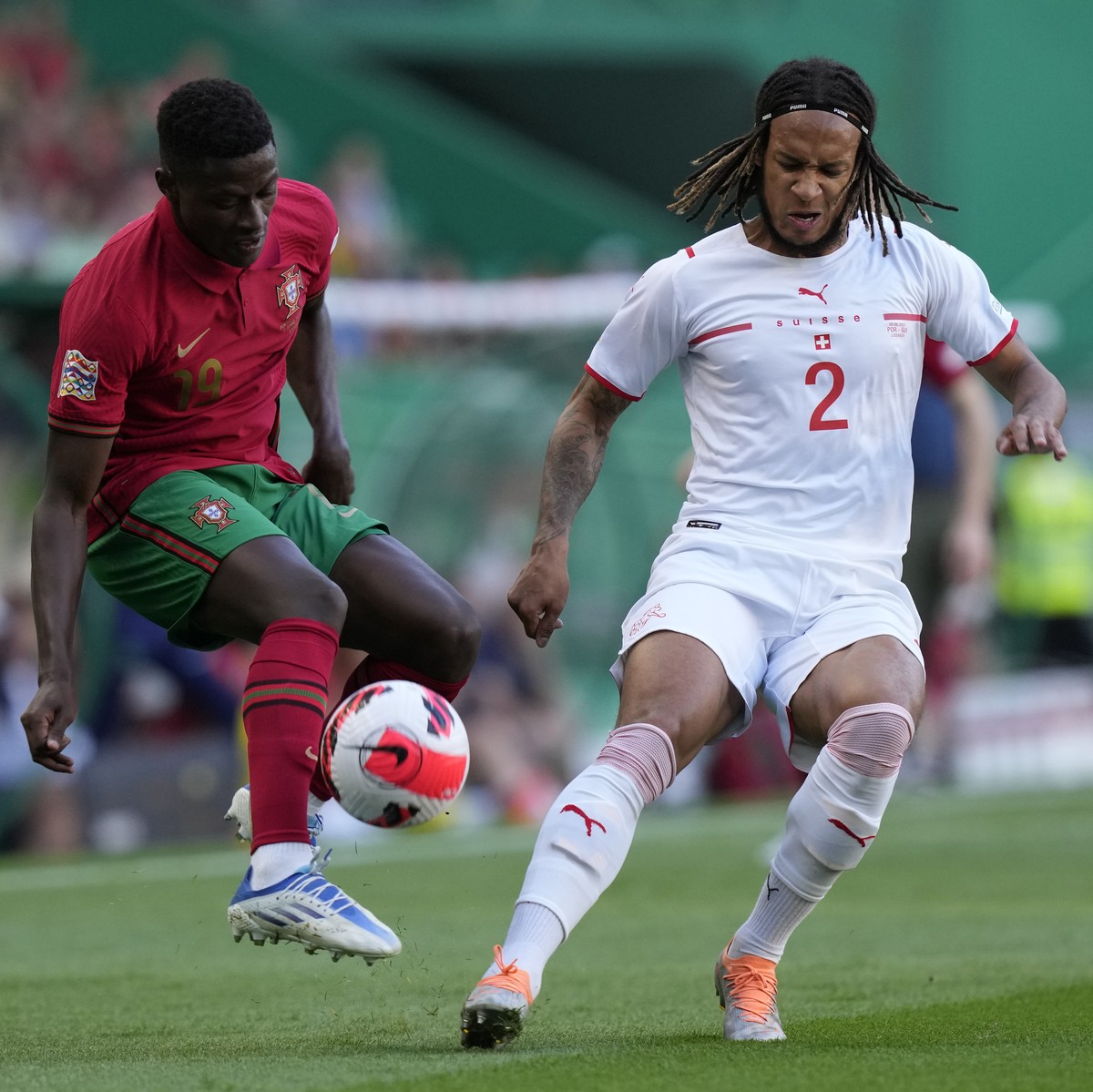 Portugal's Nuno Mendes, left, challenges for the ball with Switzerland's Kevin Mbabu during the UEFA Nations League soccer match between Portugal and Switzerland, at the Jose Alvalade Stadiu ...