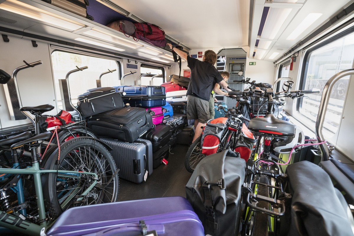 Betreuer eines Klassenlagers auf dem Weg ins Wallis bemuehen sich, das Gepaeck der Kinder ihrer Klasse neben den zahlreichen Velos im Veloabteil im unteren Stock des Familienwagens eines Intercityzuge ...