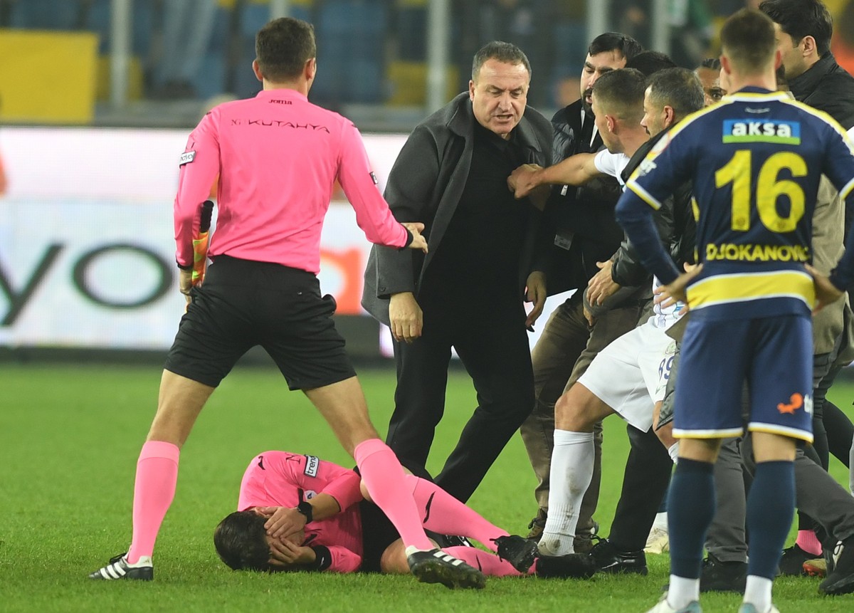 epa11024128 Turkish referee Halil Umut Meler (down) is knocked to the ground after a punch by Ankaragucu's president Faruk Koca (3-L) after the Turkish Super League soccer match between Ankaraguc ...