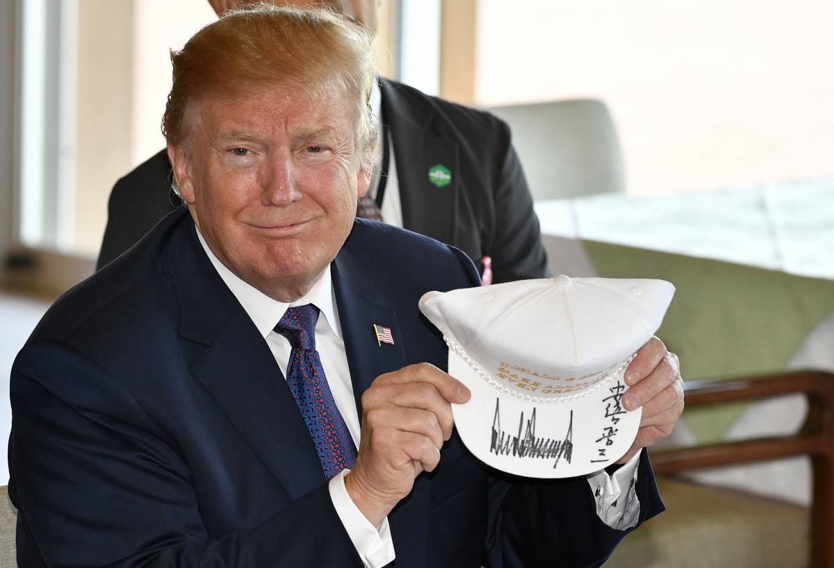 epa06309204 US President Donald J. Trump shows off a signed hat reading 'Donald and Shinzo, Make Alliance Even Greater' at the Kasumigaseki Country Club in Kawagoe, Japan, 05 November 2017.  ...