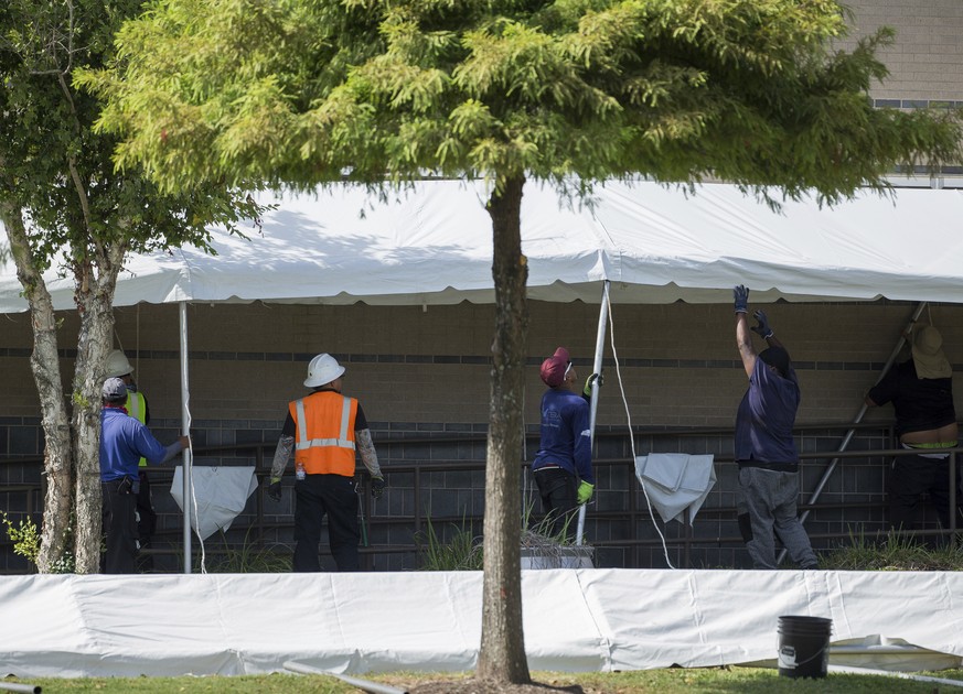 A construction crew works to set up tents that hospital officials plan to use with an overflow of COVID-19 patients outside of Lyndon B. Johnson Hospital, Monday, Aug. 9, 2021, in Houston. (Godofredo  ...