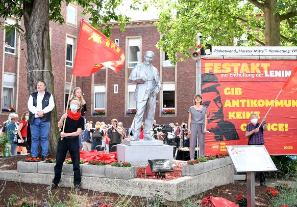 20.06.2020, Nordrhein-Westfalen, Gelsenkirchen: Gabi Fechtner, (r) MLPD-Vorsitzende und andere Parteimitglieder stehen neben der 2,15 Meter hohen Lenin-Statue nach ihrer Enth