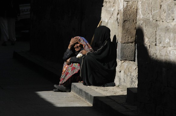 epa05703861 Yemeni women sit at a roadside in the old city of Sana&#039;a, Yemen, 07 January 2017. Yemen has been experiencing a power struggle between the Houthi rebels and the Saudi-backed Yemeni go ...