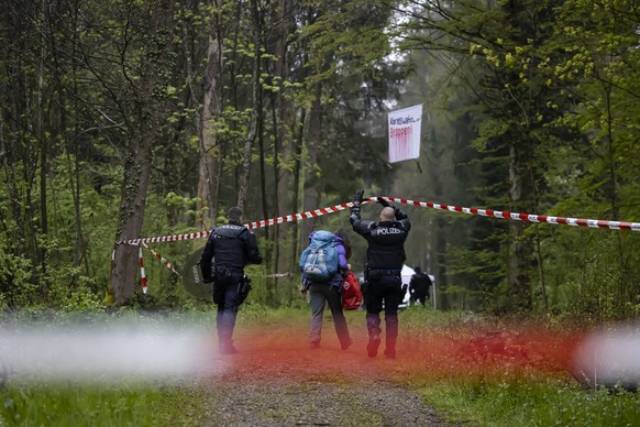 Eine Aktivistin wird von Einsatzkraeften der Polizei waehrend eines Polizeieinsatzes in einem besetzten Waldstueck nahe der Deponie Chalberhau im Ruemlanger Wald begleitet, am Donnerstag, 20. April 20 ...