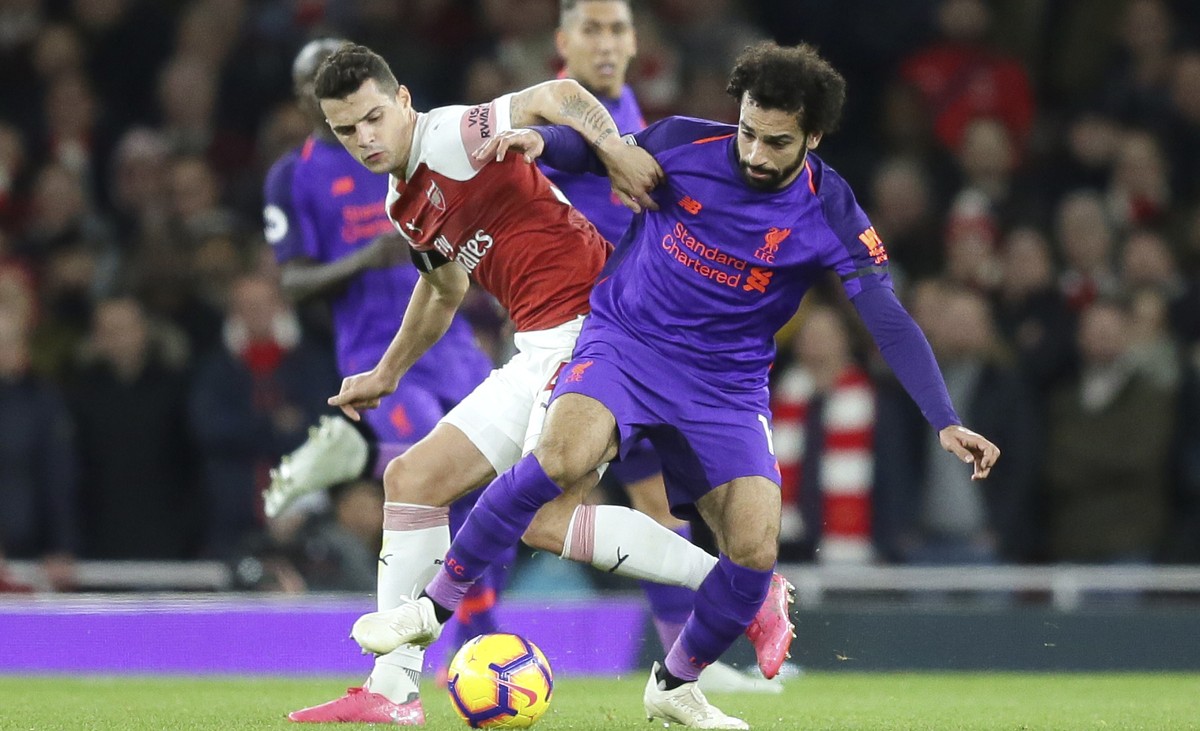 Arsenal's Granit Xhaka fights for the ball with Liverpool's Mohamed Salah, right, during the English Premier League soccer match between Arsenal and Liverpool at Emirates stadium in London,  ...
