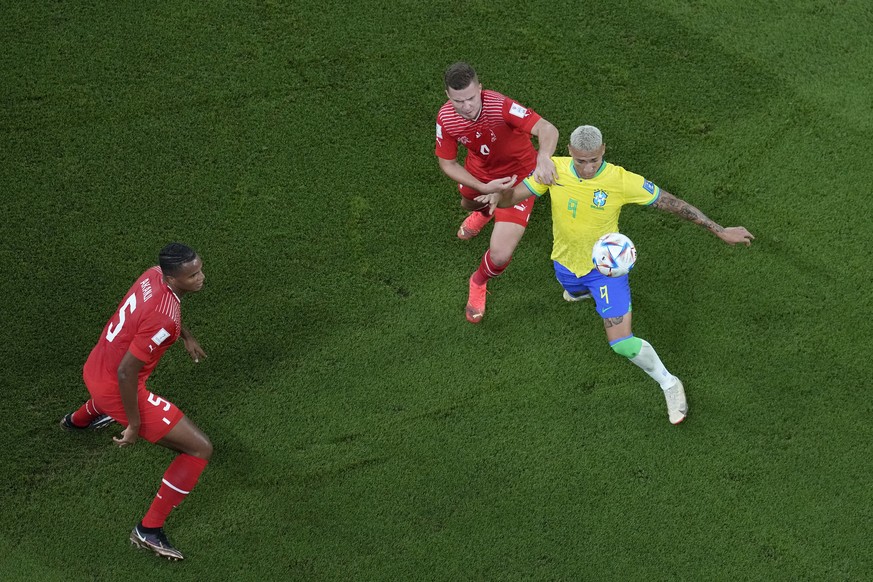 Brazil&#039;s Richarlison, right, challenges for the ball with Switzerland&#039;s Nico Elvedi, center, as Switzerland&#039;s Manuel Akanji looks them during the World Cup group G soccer match between  ...