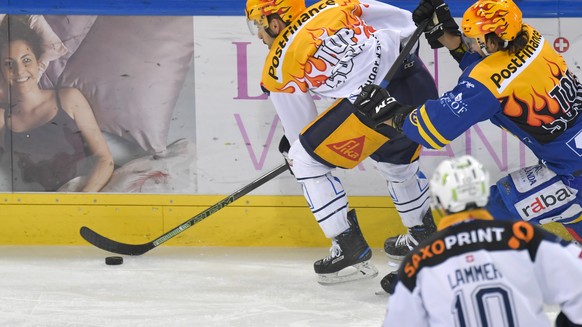 Die beiden PostFinance TopScorer Garrett Roe (US), links und Andres Ambuehl, rechts, beim Kampf um die Scheibe, beim Eishockey Meisterschaftsspiel in der Qualifikation der National League zwischen dem ...